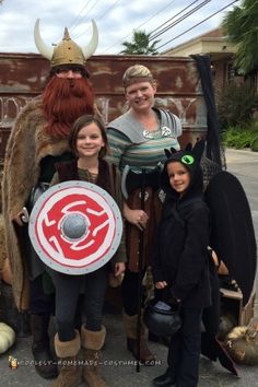 some people are dressed up in costumes and posing for a photo with one person wearing a viking costume