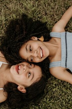 two young women laying on the grass smiling