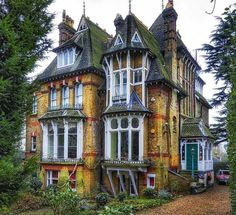 an old house with many windows and lots of trees