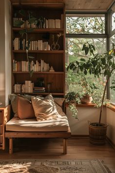 a bed sitting in front of a window next to a wooden shelf filled with books