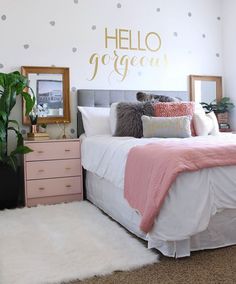 a bedroom decorated in pink and gray with polka dots on the wall above the bed