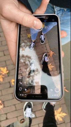 someone is holding up their cell phone to take a photo with the reflection of them