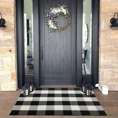 a black and white checkered rug is in front of a door with a wreath on it