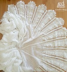 a white crocheted doily sitting on top of a wooden floor