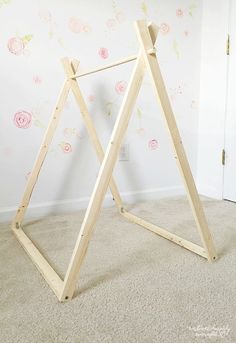 a wooden frame with flowers painted on the wall behind it in a room that has carpeted flooring