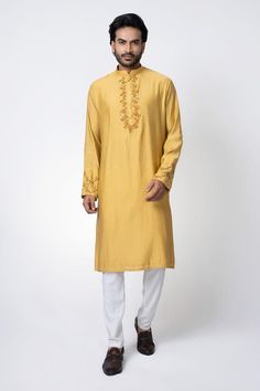 Mustard yellow straight kurta with zardosi hand embroidery. Paired with an off white pyjama.
Components: 2
Pattern: Embroidered
Neckline: Band collar
Sleeve Type: Long
Fabric: Cotton Silk
Color: Yellow
Occasion: Mehendi and Puja - Aza Fashions Semi-stitched Kurta With Gold Embroidery For Festivals, Traditional Designer Kurta With Gold Embroidery, Bandhgala With Gold Embroidery Straight Kurta For Festivals, Bandhgala With Gold Embroidery For Festivals, Traditional Bandhgala With Gold Embroidery For Eid, Ceremonial Raw Silk Kurta With Gold Embroidery, Traditional Kurta With Gold Embroidery, Traditional Gold Embroidered Kurta With Drape, Traditional Churidar With Gold Embroidery For Designer Wear