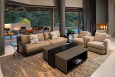 a living room filled with furniture and a fire place in the middle of an open floor plan