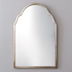 an arched mirror mounted on the wall above a sink in a room with gray walls