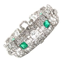 An eye-catching and wearable heirloom! The attention to detail and the dramatic design is what sets this work of art apart from the rest. Stunning 38.00 carats of multi-shaped diamonds, F/G color VS clarity are linked together by common art deco shapes in this bracelet with 4 emeralds weighing 1 carat each spread throughout accentuated by a emerald cut diamond in the center. Handcrafted in Platinum measuring 7 inches in length. Art Deco Drop Earrings, Art Deco Emerald, Platinum Bracelet, Retro Bracelet, Modern Bracelets, Art Deco Bracelet, Gatsby Style, Emerald Bracelet, Bracelet Display