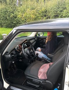 a woman sitting in the driver's seat of a car