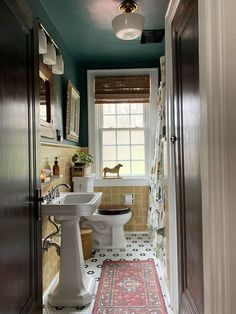 a bathroom with a sink, toilet and rug in it