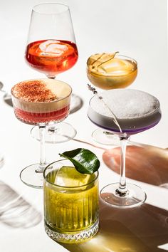 three different types of cocktails sitting on top of each other in wine goblets