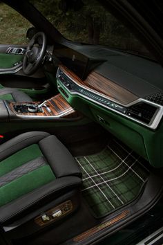 the interior of a car with green leather and wood trims, including an automatic steering wheel