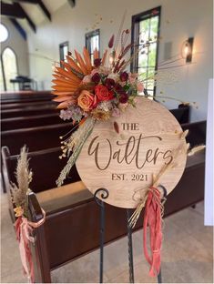 a wooden sign sitting on top of a metal stand in front of a church pew