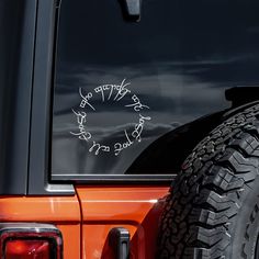 an orange jeep with writing on the back window