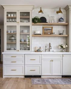 a kitchen with white cabinets and gold pulls on the cupboards is pictured in this image