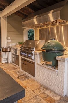 an outdoor kitchen with stainless steel appliances and grill