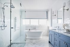 a white bath tub sitting next to a walk in shower