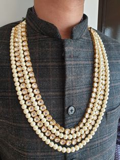 Gold Kundan Pearl Necklace For Groom, Sabyasachi Sherwani Necklace, Pearl Necklace, Long Necklace, Indian Wedding Jewelry, Pakistani Wedding 4 Layered Gold Kundan and Pearl Beads Necklace An elegant gold and pearl bead necklace with the most stunning festoon. The perfect accessory for your occasion. This necklace is handcrafted with love Necklace Length: Choose from the drop-down menu (comes with adjustable back Dori/cord) (The length of the necklace in the image is 26 inches) Package: 1 Necklace Material: Premium Pearl beads, gold kundan beads Care: Store in an airtight plastic bag or box. Keep away from water, moist places & fragrance For Express shipping, the option is available in the drop-down menu at checkout. If you need any help regarding placing an order or express shipping, feel White Temple Jewelry For Wedding And Reception, Kundan Necklaces With Round Beads For Weddings, Heavy White Kundan Necklace For Ceremonial Occasions, White Kundan Wedding Reception Accessories, Wedding Temple Necklace With Cutdana And Round Beads, White Stone Work Ceremonial Bridal Necklace, Ceremonial White Bridal Necklace With Stone Work, Heavy White Bridal Necklace For Ceremonial Occasions, Bollywood Style White Wedding Reception Dress