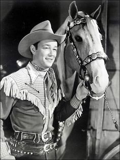 a man standing next to a horse wearing a cowboy hat