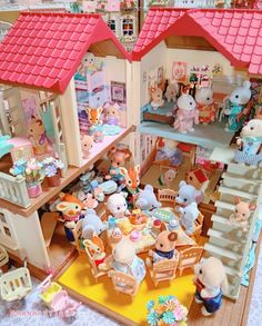 a doll house with lots of stuffed animals and toys on the floor in front of it