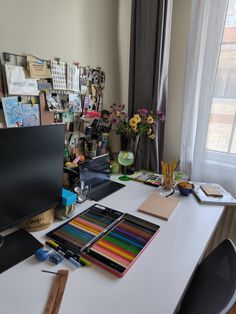 the desk is cluttered with art supplies