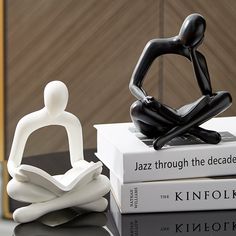 a statue sitting on top of two books next to each other with the word jazz through the decades in front of it