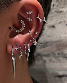 a person with some piercings on their ears and earring pieces in the shape of stars