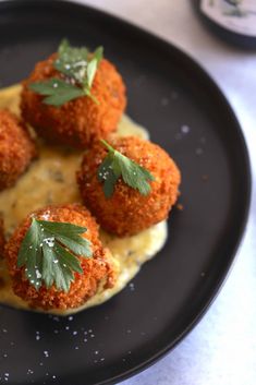 small appetizers on a black plate with parsley sprinkled over them