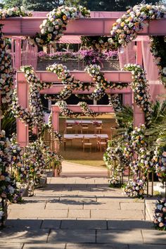 an archway decorated with flowers and greenery for a wedding or ceremony in the park