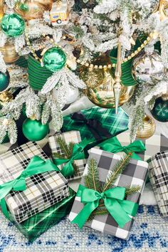 presents under the christmas tree are wrapped in green and white plaid ribbon, with ornaments around them