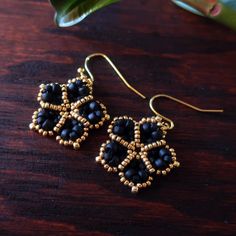 Temple Tree Mandala Flower Beaded Earrings - Matte Black and Gold Handmade Black Brass Earrings, Gold Beaded Earrings With Black Beads As Gift, Handmade Black Drop Earrings, Handmade Adjustable Black Flower Earrings, Handmade Black Drop Flower Earrings, Adjustable Gold Beaded Earrings With Black Beads, Black Earrings With Gold Beads As Gift, Gift Black Beaded Earrings With Gold Beads, Nickel-free Black Beaded Earrings For Gift