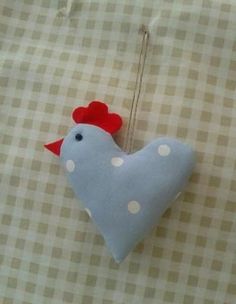 a blue and white chicken ornament hanging from a string on a checkered table cloth