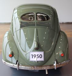 an old green car on display in a museum