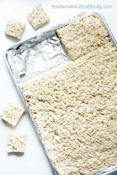 rice krispy treats in a baking pan with marshmallows on the side