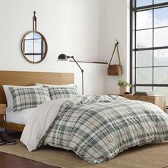 a bed in a room with a large window and wooden headboard on the wall