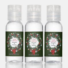 three bottles of christmas mist with holly wreath on the front and green ribbon around the top