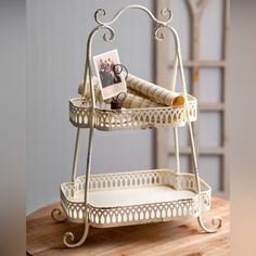 two tiered trays with books and pictures on them sitting on a wooden table