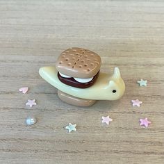 there is a small toy sandwich on top of a little elephant with stars around it