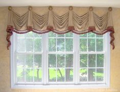 a window with curtains hanging from it's sides