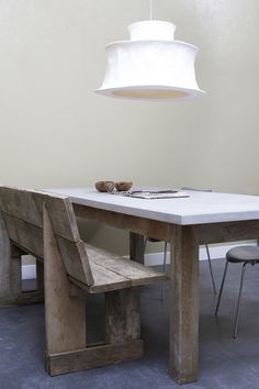 a table with two chairs and a light hanging over it in the middle of a room