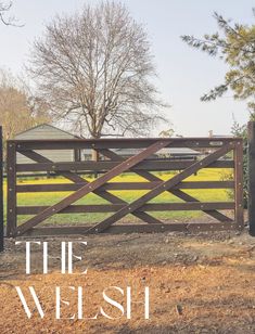 a gate with the words, the welsh on it in front of a field