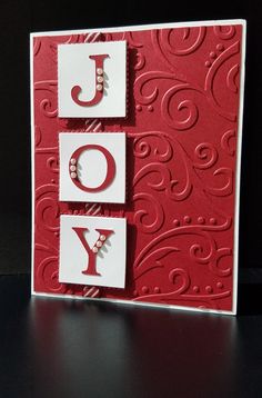 a red and white card with the word joy on it