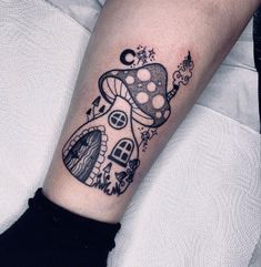 a small mushroom house tattoo on the right forearm and leg, with stars around it