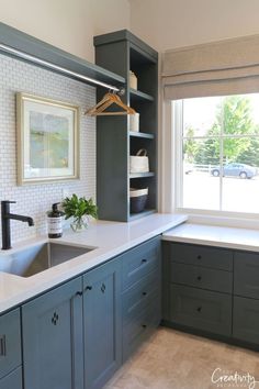 a kitchen with gray cabinets and white counter tops