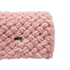 a pink knitted pillow on a white background