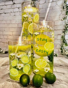 two glasses filled with lemonade and limes next to each other