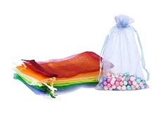 a bag filled with candy next to a pile of rainbow candies on top of a white surface