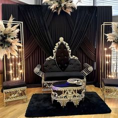 an elaborately decorated living room with black and gold furniture in front of a curtained window