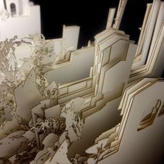 an intricately designed piece of paper with buildings in the background and trees growing out of it